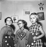 Barnträdgårdens avslutning. Tre barn dekorerade med pepparkakor av tyg.