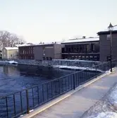 Biblioteket sett från Kapellbron. Det är vinter och snö.
Arbogaån.