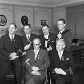 Avtackning av deltidsbrandmän. När man slutar får man en yxa samt den hjälm man använde i arbetet.
Bakre raden, från vänster: Karl-Axel Sjökvist, Olle Eriksson, Berg och Jonsson
Främre raden, från vänster: Olof Rydberg och Bertil Nordin
Eventuellt sker avtackningen i samband med brandkårens årsfest.
Festen hålls på övre våningen i Arbetareföreningens lokal på Nygatan (observera texterna på väggen).