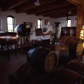 Interiör från Bryggerimuseet på Skandiagatan. Helge E Karlsson omgiven av öltunnor.