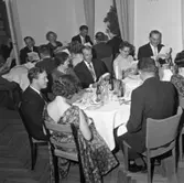 Elektrikerförbundets Arbogaavdelning har jubileumsfest. Uppklädda damer och herrar sitter till bords.