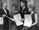 Gesällbrev delas ut. Mannen, som håller sitt gesällbrev, är Erik Rune Wahlberg, målare. Kvinnan till höger heter Daisy Haglund, damfrisörska.