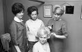 Gesällprov för damfrisörskor. Birgitta Karlsson (gift Segerstedt) håller i kammen och justerar det sista på Ing-Britt Karlssons frisyr. Ann-Christine Lundgren (längst till vänster) och okänd, ser på.