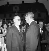 Konung Gustaf Vl Adolf gästar Arboga under sin Eriksgata. Här samtalar har med riksdagsman Iwar Andersson, på Stora torget. Bakom kungens rygg ses Sigfrid Silfverling på Koberg.
För värdskapet, under kungens besök, svarade stadsfullmäktiges ordförande Jonas Carlsson och kommunalborgmästare Danliel Ekelund. Den organisationskommitté som ansvarade för arrangemangen, hade hos drätselkammaren begärt en summa av 3000 kronor för att täcka kostnaderna vid kungabesöket. Beloppet beviljades. 
Tiden för kungens besök var beräknad till 130 minuter.