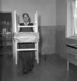 Inflyttning i Gäddgårdsskolan. Vaktmästaren bär stolar.