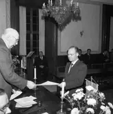 Hantverksföreningens ordförande, Gustaf Johansson (Murar-Gustaf) delar ut mästarbrev till maskinelektriker Åke Haglind.
Bilden är tagen i fullmäktigesalen på Rådhuset.