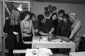 Keramikkurs hos Ulf Johansson. Här visar han hur man drejar. Kvinnan längst till vänster är Eva-Lita Harlin Alm. De tre kvinnorna längst till höger är identifierade: fru Oscarsson (med vit krage), Ulla Hellström (med halssmycket) och Karin Liljeborg (kallad 