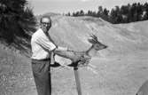 Lennart Molin vid jaktskyttebanan. Han håller i en pappmodell av ett rådjur med måltavla på.