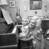 Familjen Ström vid pianot. Rune och Margareta med dottern Fredrika 