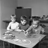 Matematik-klinik
Tre pojkar studerar mängdlära i matematiken. Till sin hjälp har de träplattor i olika former.