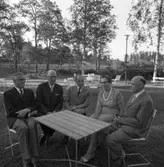 Skolstyrelsen avtackar lärare.
Från vänster: okänd, Rolf Danielsson (matematik och fysik), Tore W Ekman (skolstyrelsens ordförande), okänd och Gunnar Tallqvist
De sitter utomhus, i trädgårdsmöbler. Platsen är Vinbäcken.