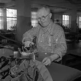 Skräddare Karl Lennbom vid Albin Rapps Konfektionsfabrik
Man som pressar en söm med ett strykjärn.
