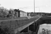 Strömsnäsbron, över Arbogaån, fotograferad från norra sidan. Vårdcentralen till vänster. Höghusen på Västermovägen, Brattberget, skymtar i bakgrunden.