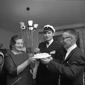 Lars-Göran Rådström har klarat studentexamen. (Han tillhör den sista kullen med muntliga förhör).
Mamma Karin och pappa Egon håller i tårtan.