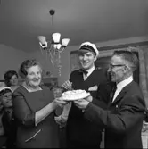 Lars-Göran Rådström har klarat studentexamen. (Han ingick i den sista kullen som hade muntliga förhör).
Mamma Karin och pappa Egon håller i tårtan.
I bakgrunden ses studentkamraten Hans Grönkvist, Lars-Görans storasyster Mona-Lisa Bergström och hennes son Tomas Bergström.