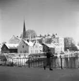 Vintermotiv. En pojke går över Kapellbron. Han bär sina skidor på axeln och håller stavarna i handen. I bakgrunden ses Labron/Ladbron, 