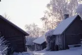 Ågårdar på Arbogaåns norra sida, längs Västerlånggatan. Det är vinter och snö.