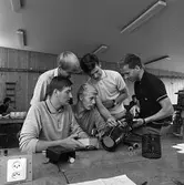 Yrkesskolan. Lärare Åke West tillsammans med elever.
De båda stående eleverna är: okänd och Hans Hellberg
De båda sittande eleverna är: Bengt Jonsson (Korv-Jonsson) och Gunnar Franzén
De studerar en elektrisk apparat