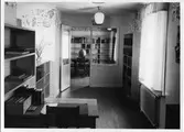 Biblioteksinteriör med bokhyllor, böcker, ett skrivbord, en glasdörr och en jordglob.
Troligen från biblioteket på Nygatan.
Baksidan på fotografiet hittas på AKF-14449