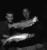 Laxfångst i hamnen. Erik Persson till höger.
Två stolta fiskare med var sin stor lax.