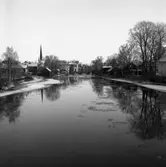 Utsikt från Strömsnäsbron. Ågårdar söder och norr om Arbogaån. Kapellbron mitt i bild. Heliga Trefaldighetskyrkan till höger och brandstationen anas bakom träden. Det är vinter. Isskärvor på ån.