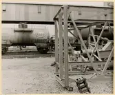 Stålkonstruktioner vid Oxelösunds hamn. I bakgrunden ett godståg.