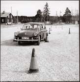 Sigvard Ljungs manövreringsförmåga med sin bil testas i en konad bana under ett bilrally anordnat av Trafikaktiebolaget Grängesberg - Oxelösunds Järnvägar, TGOJ.