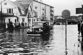 Översvämning på Göteborgsvägen, 1950-tal. Från vänster ses Göteborgsvägen 7 (Såpan) och 9. 
Längre bort ses Ekmans gård på nuvarande Stadshusplatsen. En lätt lastbil forcerar vattenmassorna.