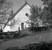 Döderhults kyrka med stenmuren i förgrunden.