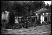 Man som undersöker något föremål efter branden i vagnhallen på industriområdet Aga, på Lidingö 1949-09-19.