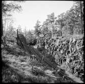 Linjebild längs med Saltsjöbanan, motorvagnståg passerar en skärning.