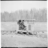 Industrilok med förare och passagerare.