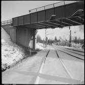 Viadukt över vintrigt järnvägsspår.