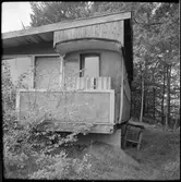 Personvagn 2:a klass ombyggd till en variant av bostad med ett förstärkt tak. Utbyggnad till vänster om vagnen.