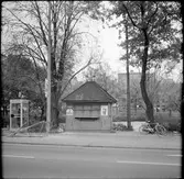 Samtal i telefonkiosk bredvid en igenbommad kiosk.