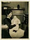 Porträtt. Kvinna med bebis i famnen