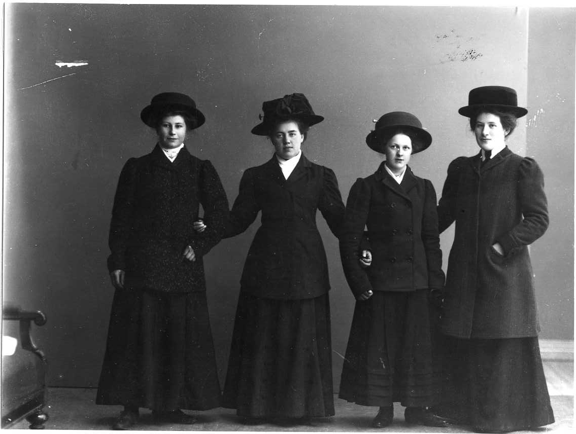 Calla Helena Sundbeck, Gruppbild med fyra unga kvinnor i ytterkläder och hatt på huvudet. Från vänster: Elvira Pettersson från Bohult, Edla Andersson från Aranäs, Elsa Tell samt Hanna Blixt från Aranäs.