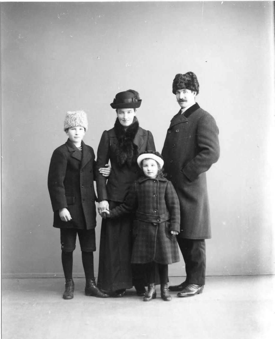 Calla Helena Sundbeck, Gruppbild med familjen Karlsson, vinterklädda med huvudbonader i ateljén. Hugo Karlsson håller vänster hand om mamman Anna Karlssons högra arm. Hon håller i samma hand dottern Gretas hand. Till höger står pappan Oskar Karlsson.