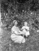 Mor med lliten dotter i naturen.