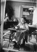 Kvinna vid symaskin, Östhammar, Uppland