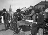 Torghandel på Stortorget, torgstånd med handlare och kunder.