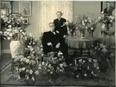 H.M. Enander med sin fru Anna fotograferade omgivna av blommor på guldbröllopsdagen 1949.