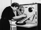 Bokföringens datacentral. Uppgifterna på pappersremsan - med de stansade hålen - skall nu föras över på magnetband. Fru Gunnel Kupferschmidt monterar in remsan.