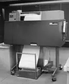 Bokföringsavdelningens datacentral. Snabbskrivare skriver ut en bokföringslista med en hastighet av 1200 rader i minuten. Bokföringslistorna bindes och bildar de uppslagsverk som anlitas vid bl a telefonuppsägningar.