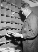 Överpostiljon G E B Oppstedt sorterar brev och samlingskuvert med
jul- och nyårskort.