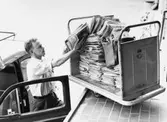 Lokalbrevbärare i Farsta 1965. Med anledning av personalbrist vid
postkontoret Farsta 1, måste brevbäraren använda sin egen bil som
depå för buntarna. Det saknades personal för att köra ut posten till
brevbäringsdistriktens avbuntningslådor.