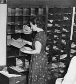 Försortering på postkontoret i Kisa, maj 1949. Postbiträdet Ulla Ericsson sorterar till lantbrevbäraren, boxar och fack m.m.
