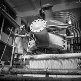 Man i arbete vid sliperiet på pappersbruket Papyrus i Mölndal, 6/5 1955.