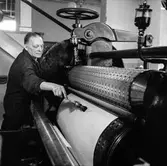 Man i arbete vid gauffrerkalander nr 5 på pappersbruket Papyrus i Mölndal, 6/5 1955.
