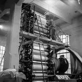 Åke Lundgren, som arbetade som glättare, i arbete vid maskin på pappersbruket Papyrus i Mölndal, 6/5 1955.